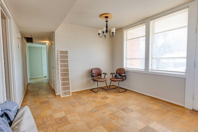 unfurnished room featuring an inviting chandelier and baseboards