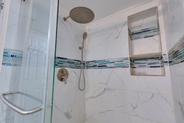 bathroom featuring a marble finish shower