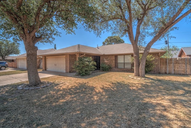 ranch-style home featuring an attached garage, fence, brick siding, driveway, and a shingled roof
