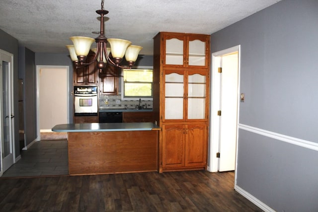 kitchen with white oven, dark wood-type flooring, sink, pendant lighting, and black dishwasher