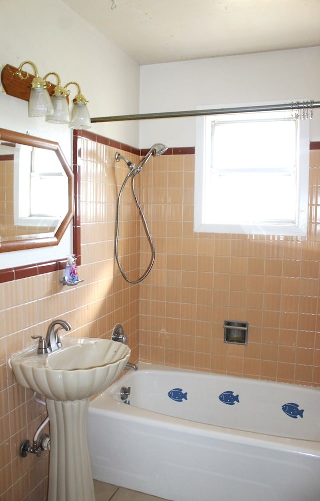 bathroom with tiled shower / bath, a wealth of natural light, and tile walls