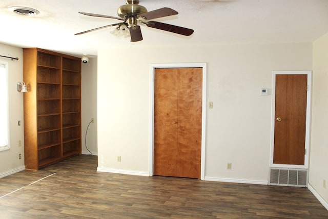 unfurnished room with ceiling fan and dark hardwood / wood-style flooring