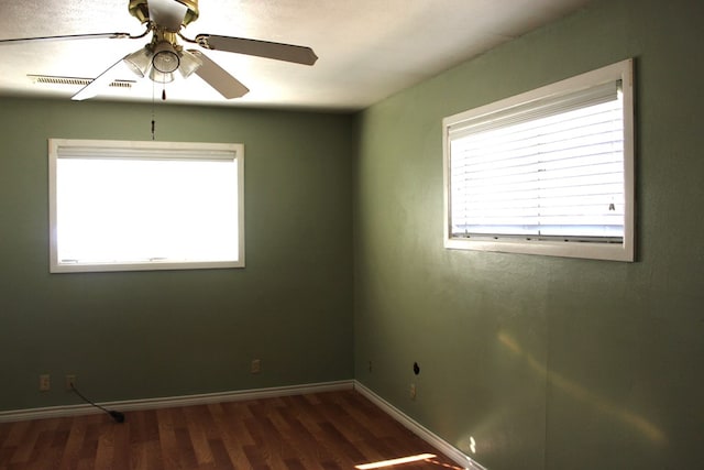 empty room with ceiling fan and dark hardwood / wood-style floors