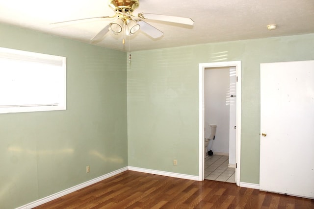 empty room with dark hardwood / wood-style floors and ceiling fan