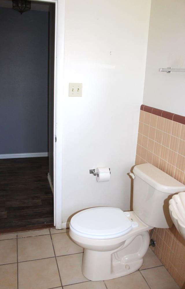 bathroom with tile patterned floors, tile walls, and toilet