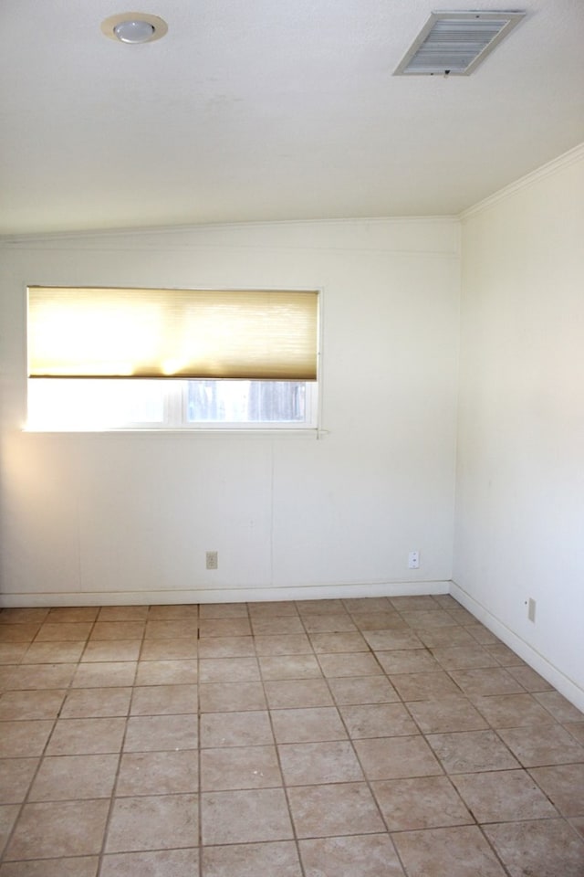 empty room with crown molding and light tile patterned flooring