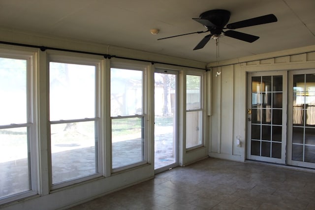 unfurnished sunroom with plenty of natural light and ceiling fan