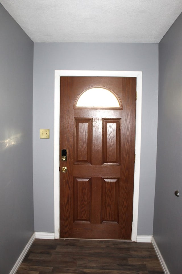 foyer with dark hardwood / wood-style flooring and a textured ceiling