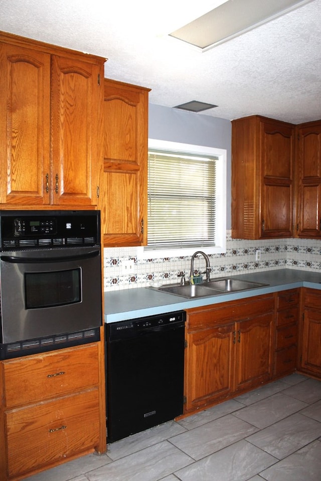 kitchen featuring black appliances, backsplash, sink, and a textured ceiling