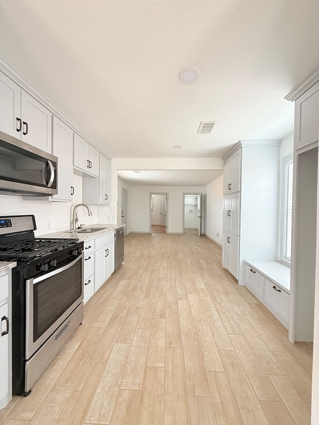 kitchen featuring light hardwood / wood-style floors, white cabinetry, sink, and appliances with stainless steel finishes