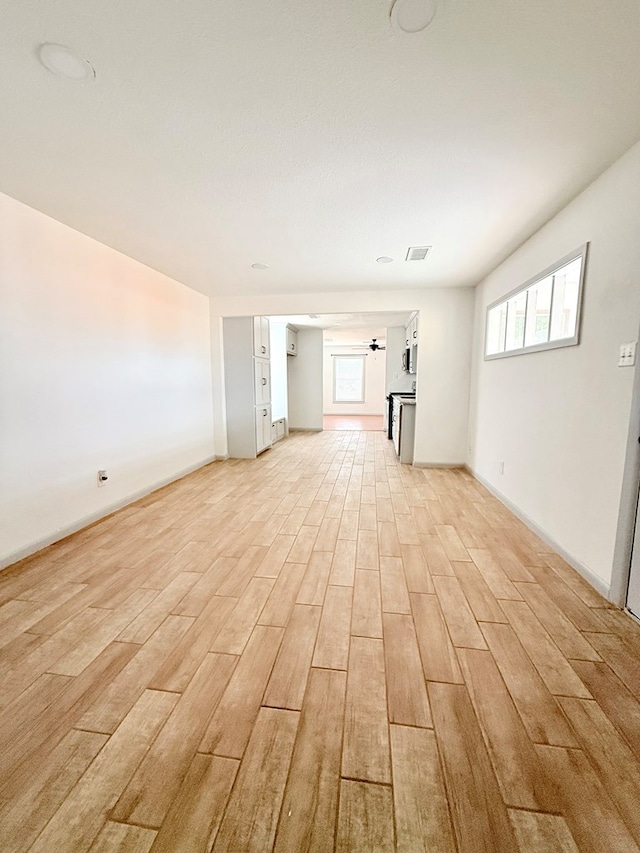 unfurnished living room featuring ceiling fan and light wood-type flooring