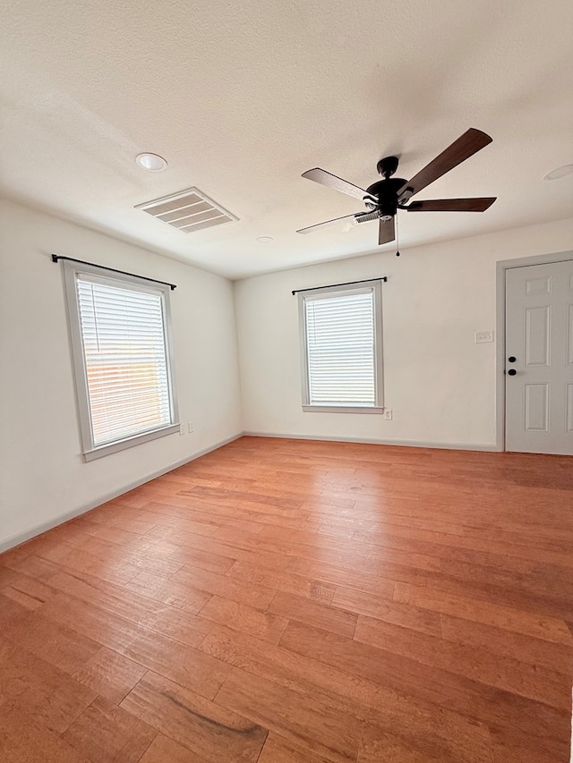 unfurnished room featuring ceiling fan, light hardwood / wood-style flooring, and a healthy amount of sunlight