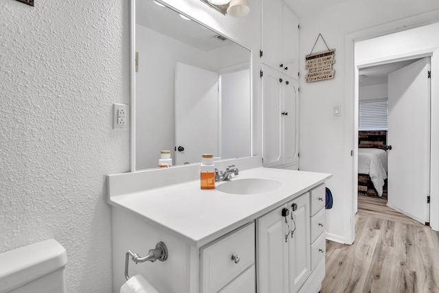 2108 Cecilia, Big Spring, TX 79720 - half bath with vanity, wood finished floors, ensuite bath, and a textured wall