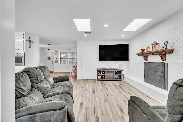 2108 Cecilia, Big Spring, TX 79720 - living room featuring a skylight, light wood-type flooring, brick wall, and recessed lighting
