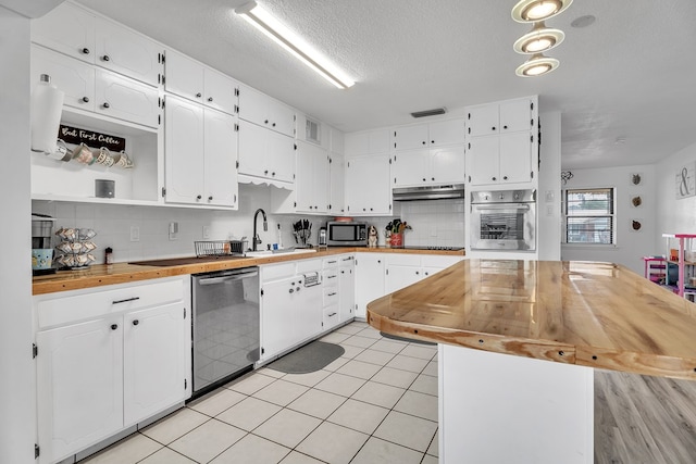 2108 Cecilia, Big Spring, TX 79720 - kitchen with stainless steel appliances, wood counters, under cabinet range hood, white cabinets, and a textured ceiling