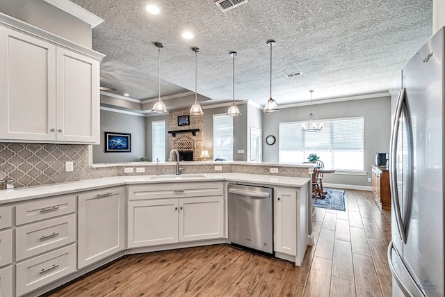 kitchen with white cabinetry, sink, crown molding, and stainless steel appliances