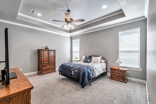 bedroom with light carpet, ceiling fan, a tray ceiling, crown molding, and multiple windows