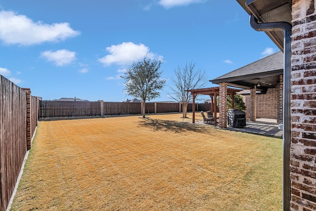 view of yard featuring ceiling fan and a patio