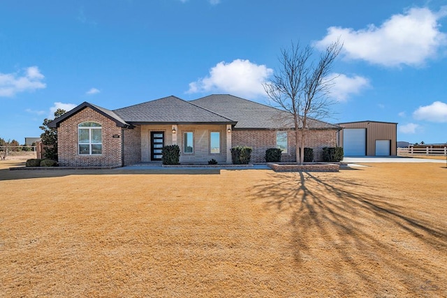 view of front of house with a garage, a front yard, and an outdoor structure