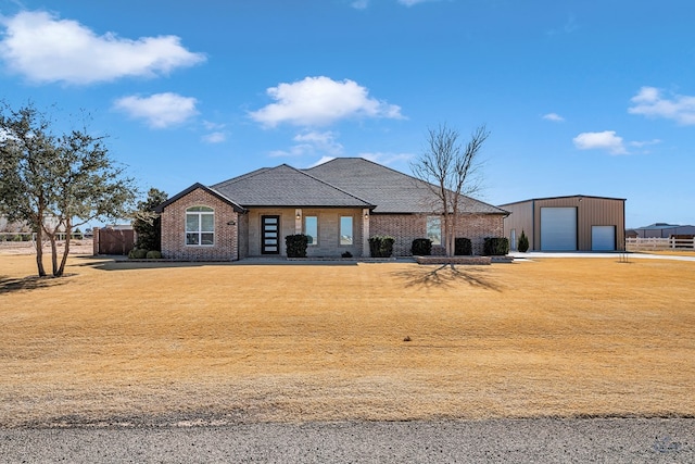 view of front of house featuring an outbuilding, a front lawn, and a garage