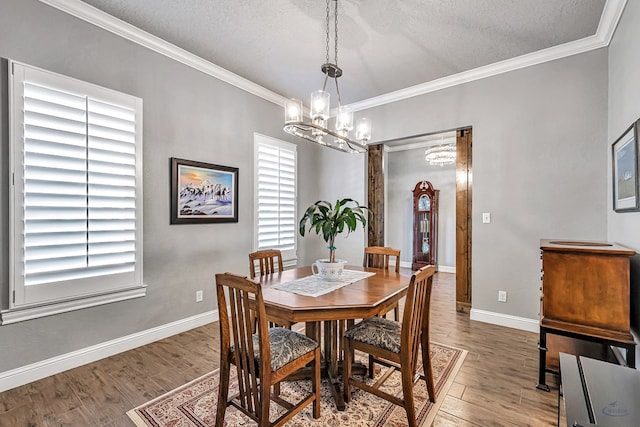 dining space featuring a textured ceiling, a chandelier, ornamental molding, and wood-type flooring