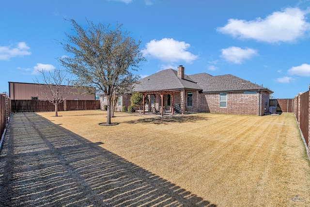 back of house with a lawn and a patio