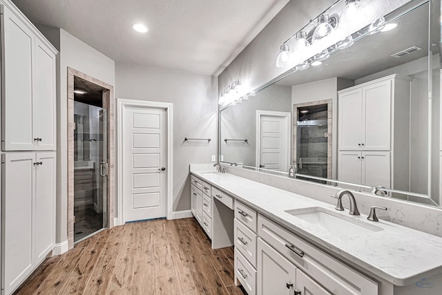 bathroom featuring vanity, wood-type flooring, and an enclosed shower