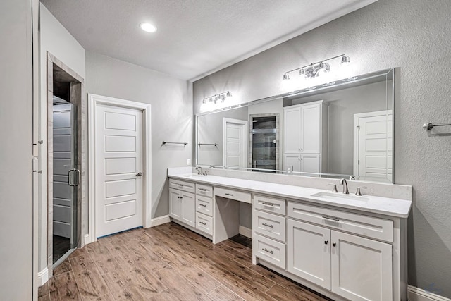 bathroom featuring walk in shower, vanity, and hardwood / wood-style floors