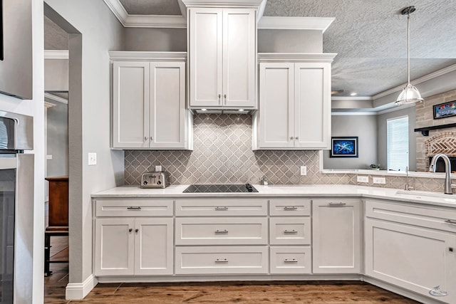 kitchen with white cabinets, dark wood-type flooring, sink, hanging light fixtures, and black electric cooktop