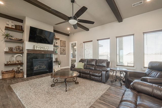 living room featuring baseboards, visible vents, a ceiling fan, dark wood-style floors, and a fireplace