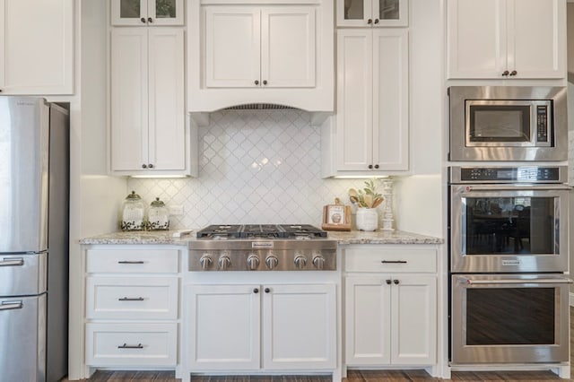 kitchen featuring stainless steel appliances, white cabinets, and glass insert cabinets