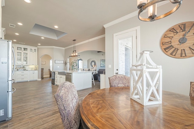 dining room featuring visible vents, arched walkways, ornamental molding, dark wood-style flooring, and recessed lighting