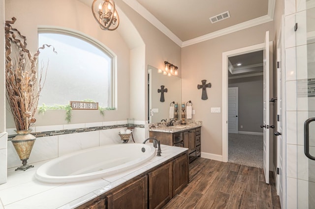 bathroom featuring visible vents, wood finished floors, crown molding, vanity, and a bath