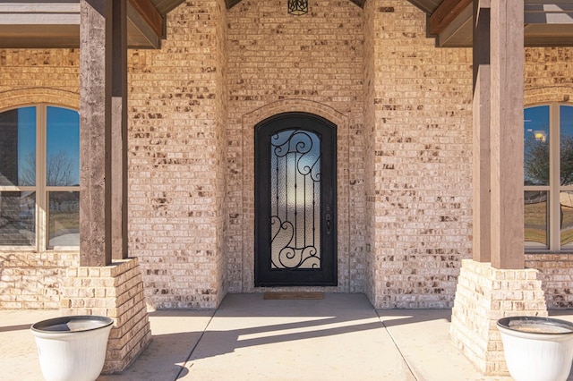 view of exterior entry with brick siding