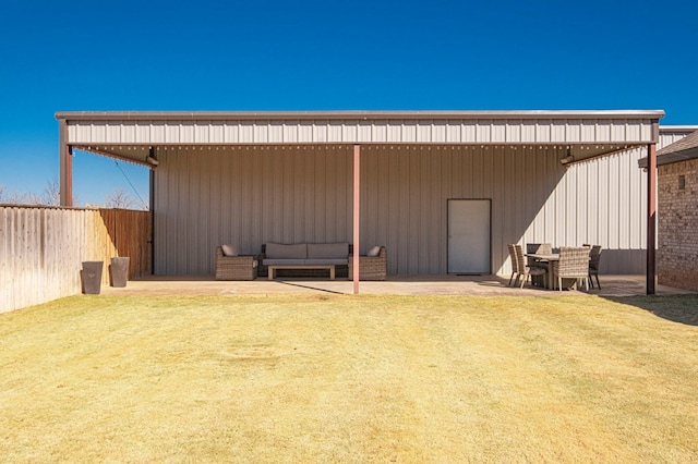 back of house featuring a lawn, fence, a patio area, outdoor lounge area, and a carport