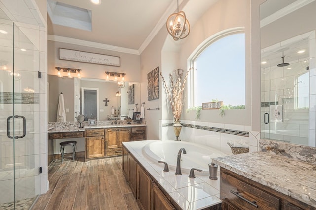 full bathroom with a garden tub, ornamental molding, a stall shower, vanity, and wood finished floors