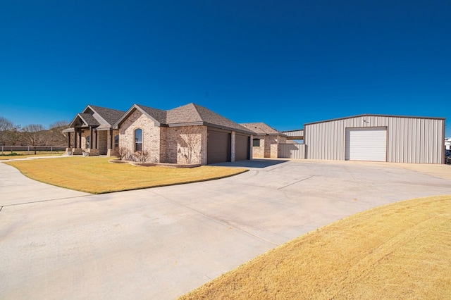 view of front of property with board and batten siding, concrete driveway, brick siding, and a front lawn