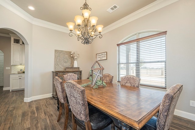 dining space featuring arched walkways, visible vents, baseboards, ornamental molding, and dark wood finished floors