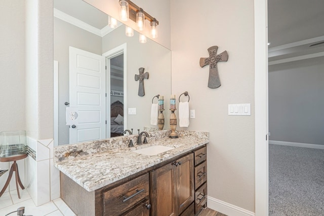 bathroom featuring baseboards, ornamental molding, and vanity