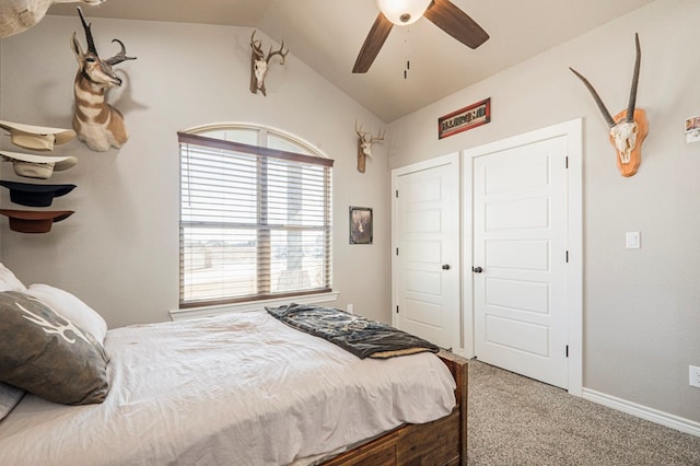 carpeted bedroom featuring lofted ceiling, ceiling fan, baseboards, and a closet