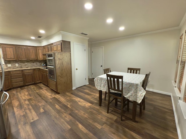 3612 Oakridge Dr, Midland, TX 79707 - kitchen featuring dark wood finished floors, ornamental molding, tasteful backsplash, recessed lighting, and stainless steel double oven