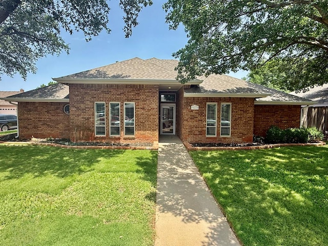 3612 Oakridge Dr, Midland, TX 79707 - view of front of home with brick siding, a front yard, and a shingled roof