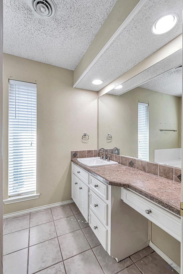 bathroom with tile patterned flooring, vanity, and a textured ceiling