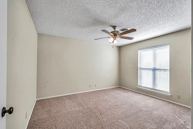 empty room featuring ceiling fan, carpet floors, and a textured ceiling