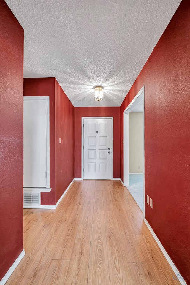 entryway featuring a textured ceiling and light wood-type flooring