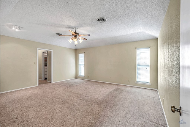 carpeted empty room featuring ceiling fan and a textured ceiling