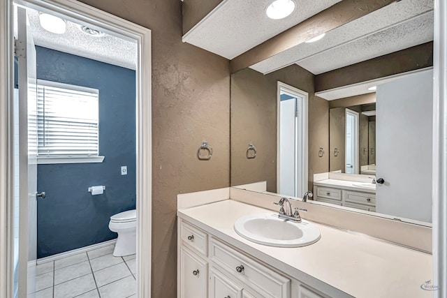 bathroom featuring tile patterned floors, toilet, vanity, and a textured ceiling