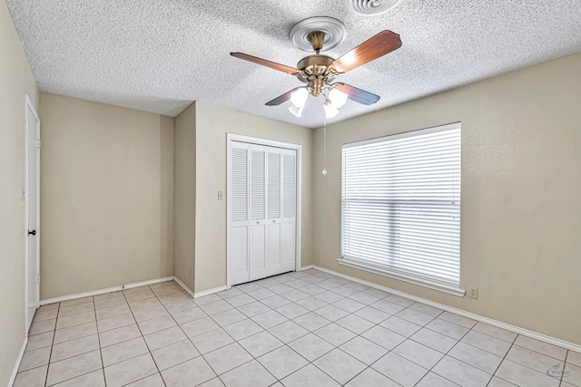 unfurnished bedroom with ceiling fan, a closet, and a textured ceiling