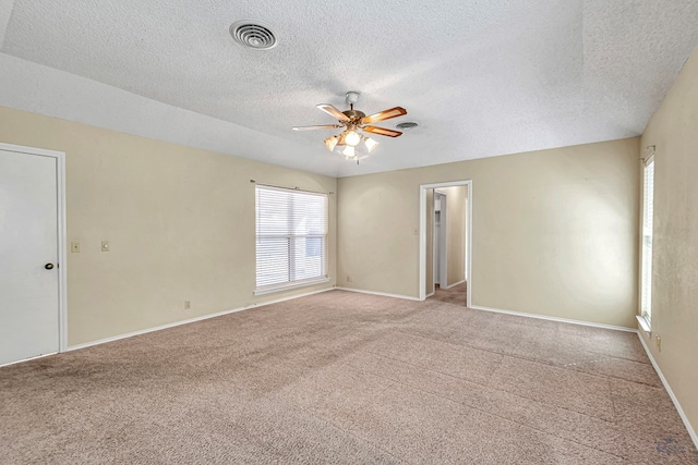 carpeted spare room with a textured ceiling and ceiling fan