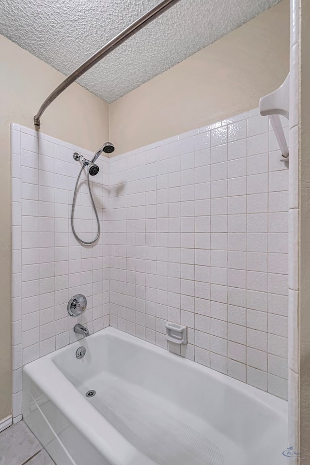 bathroom with tiled shower / bath and a textured ceiling